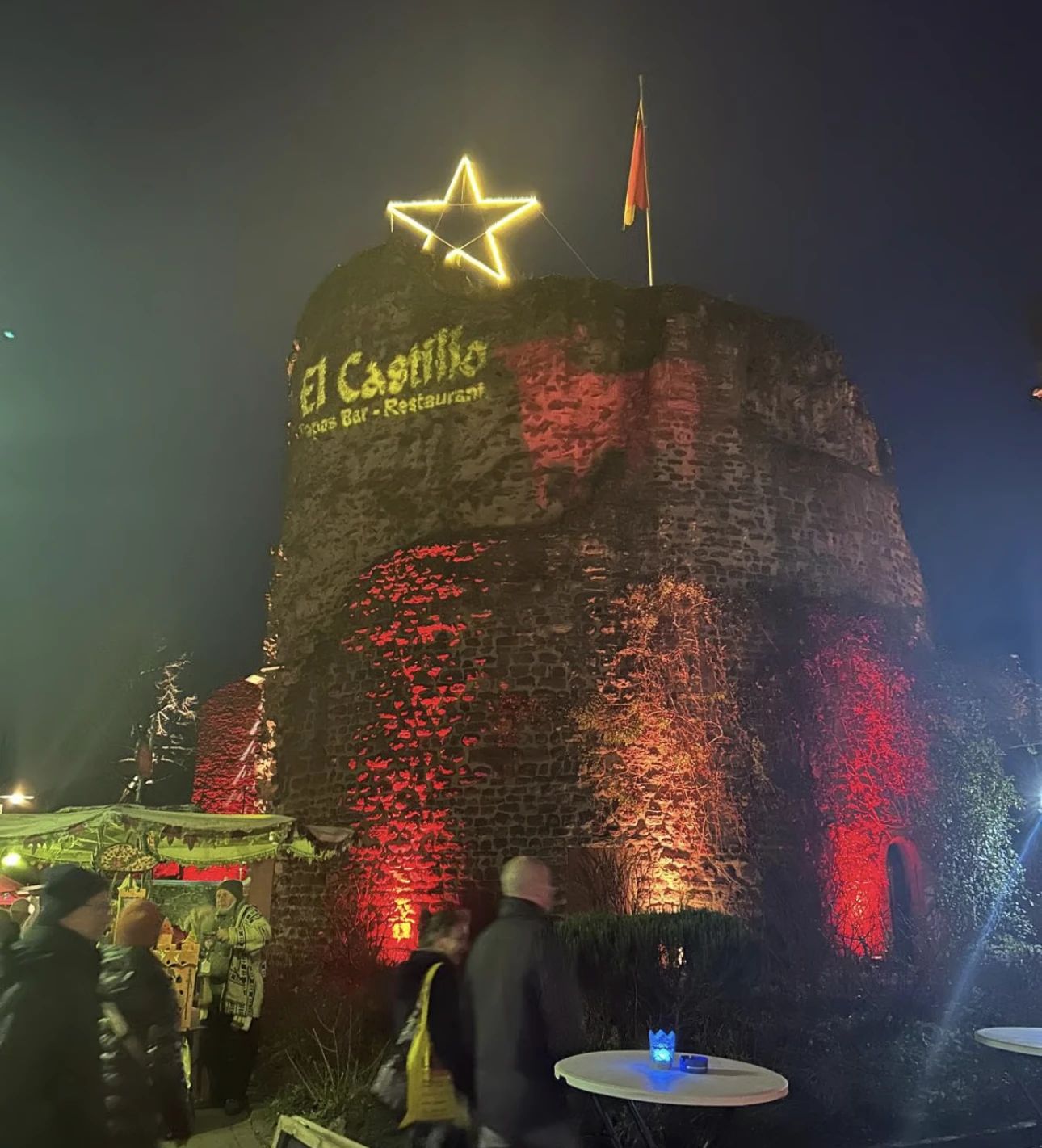 Die Burg Hayn am Abend, rot beleuchtet mit El-Castillo-Schriftzug und leuchtendem Stern