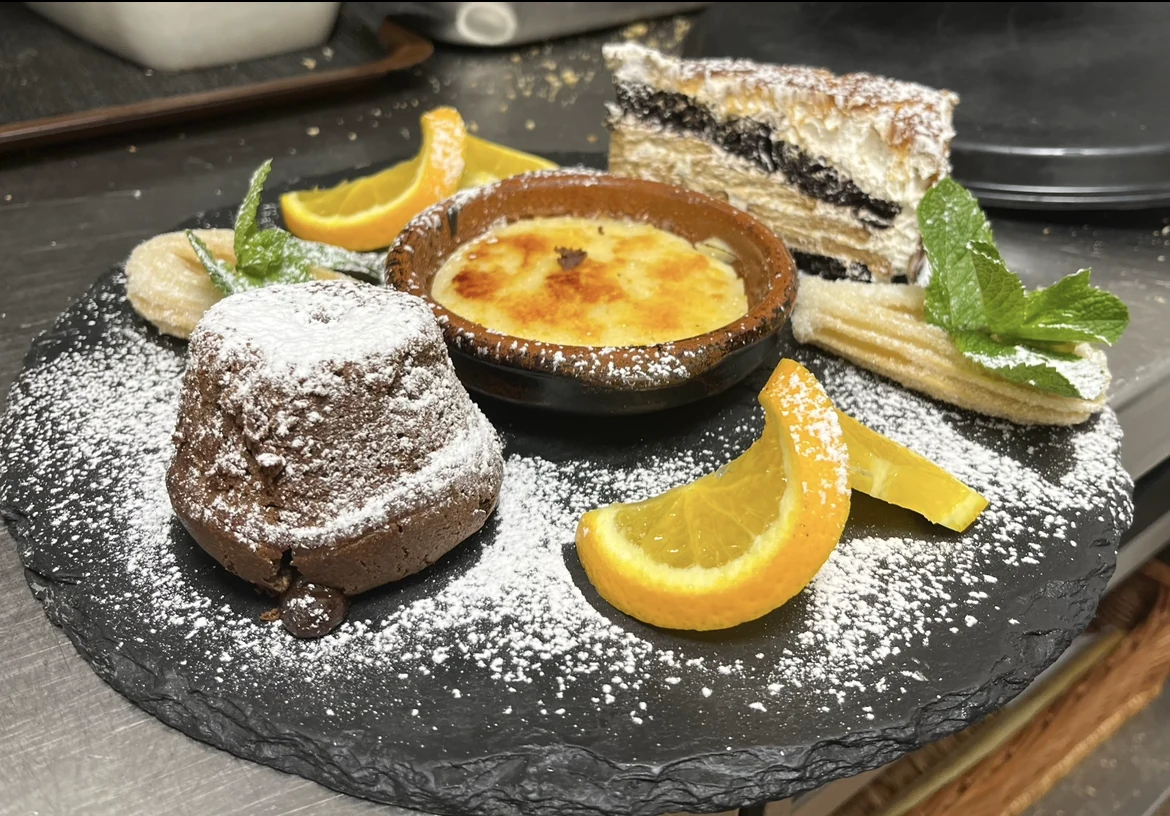 Dessertplatte mit karamellisierter Creme, Schokoküchlein, Churros und Obst
